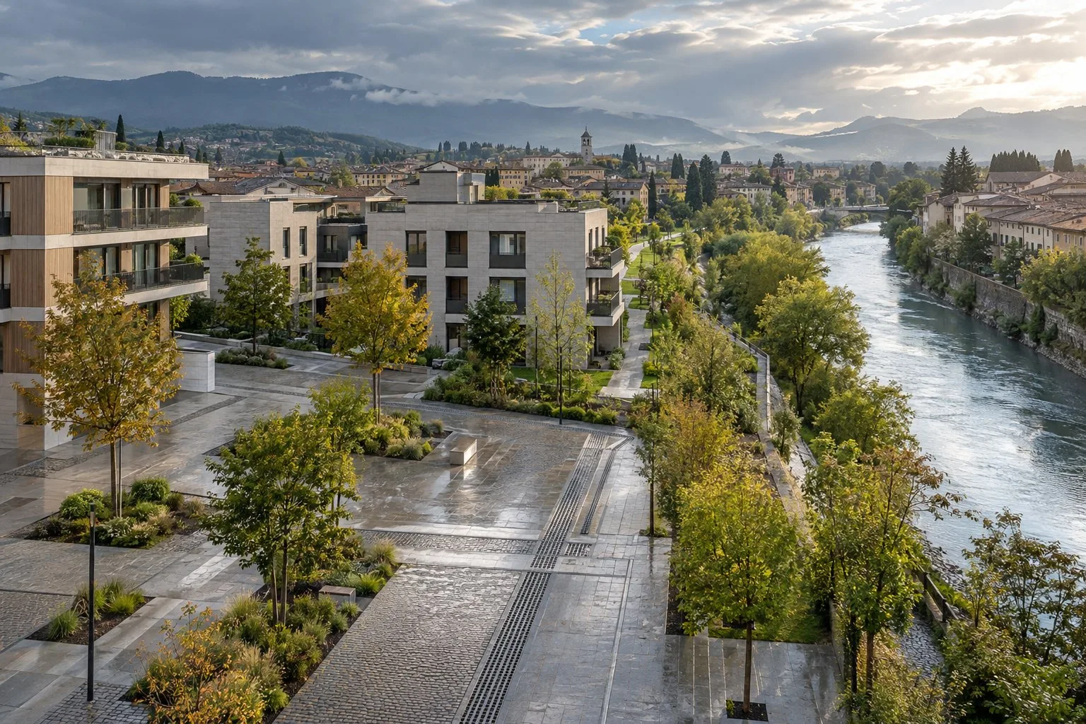 Edifici e spazi pubblici lungo un corso d’acqua, con verde e pavimentazioni dopo la pioggia